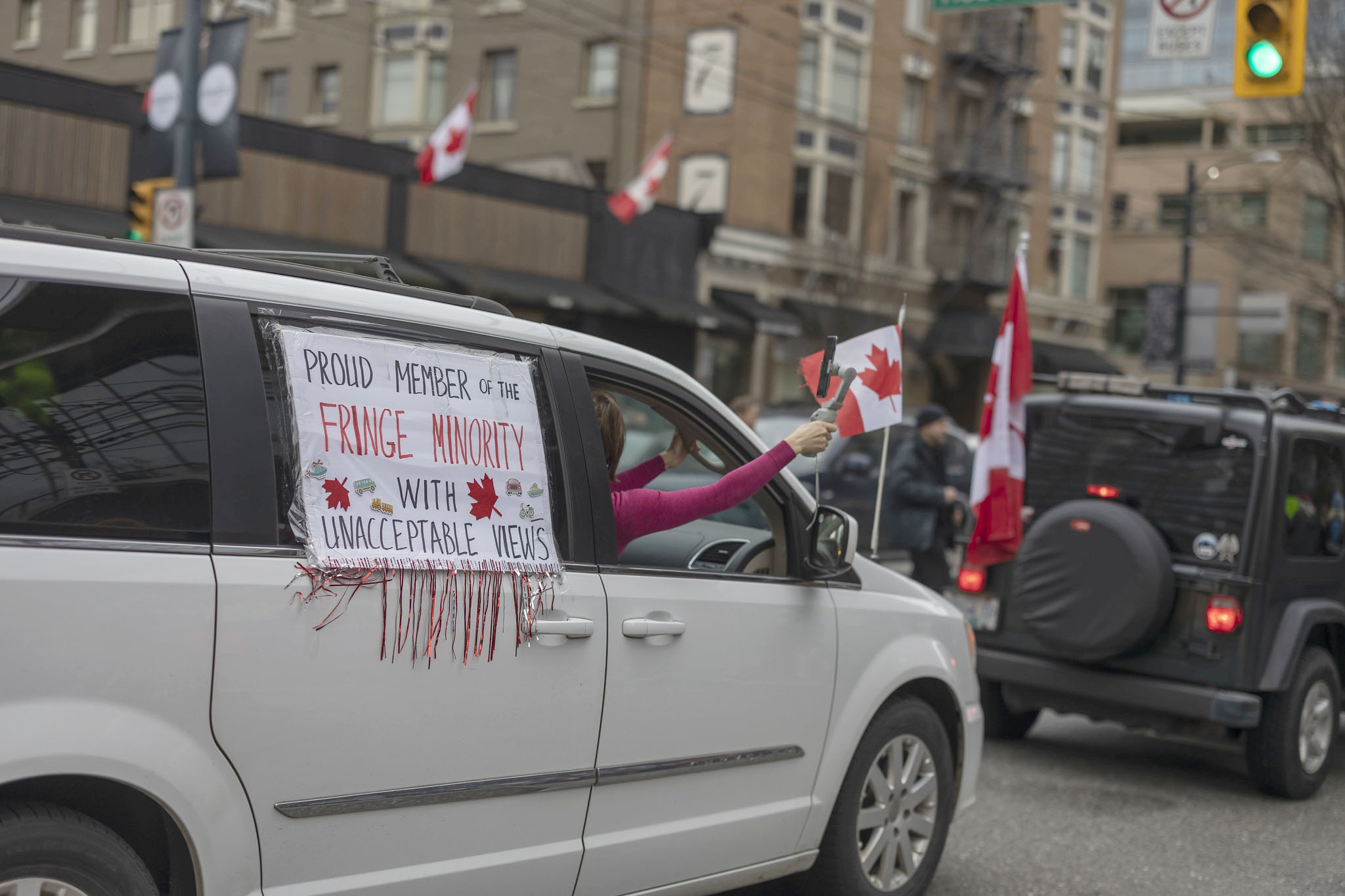 Protesters in Canada - a sign on the side of a car says "proud members of the fringe minority"