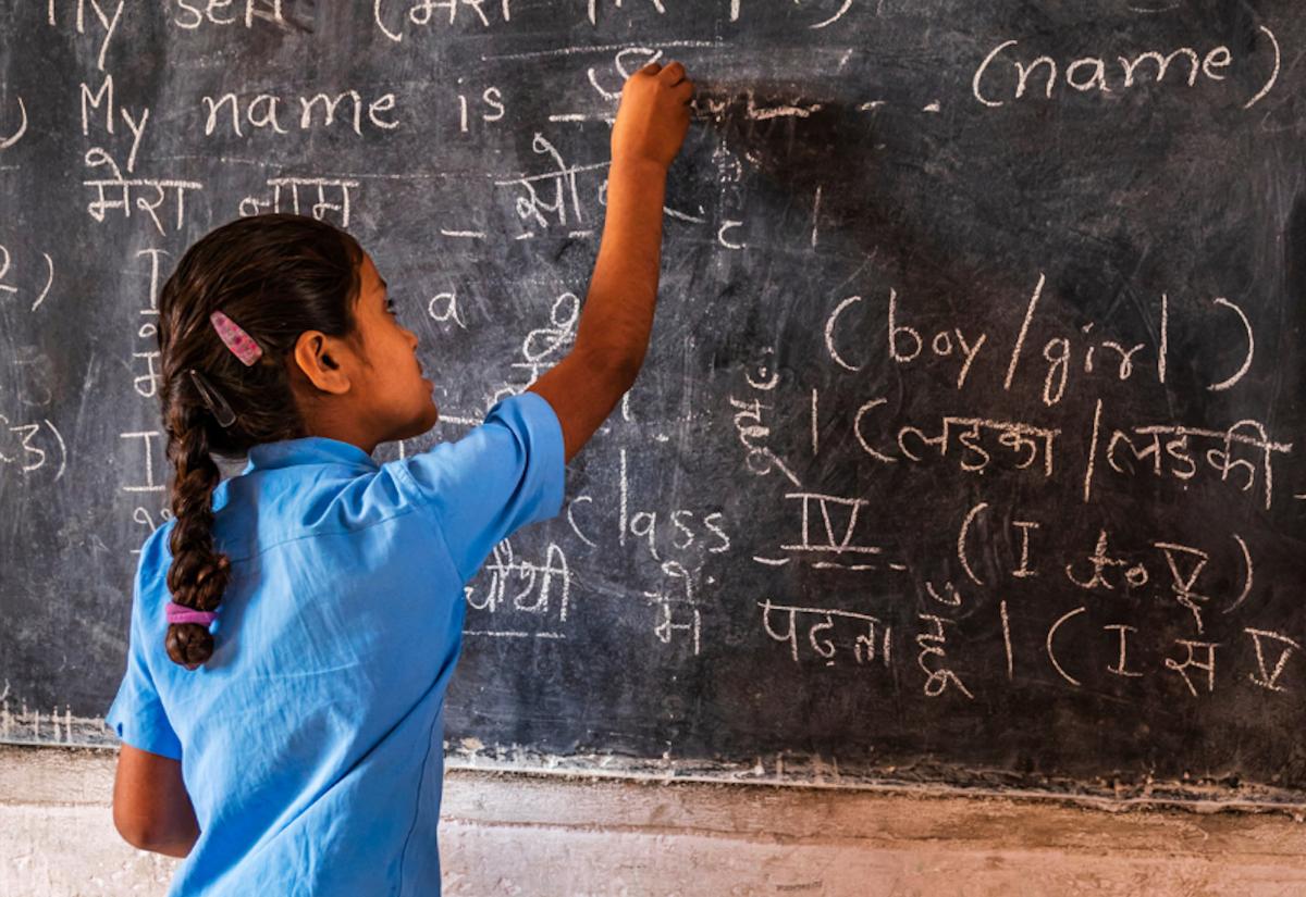 Girl draws on chalkboard